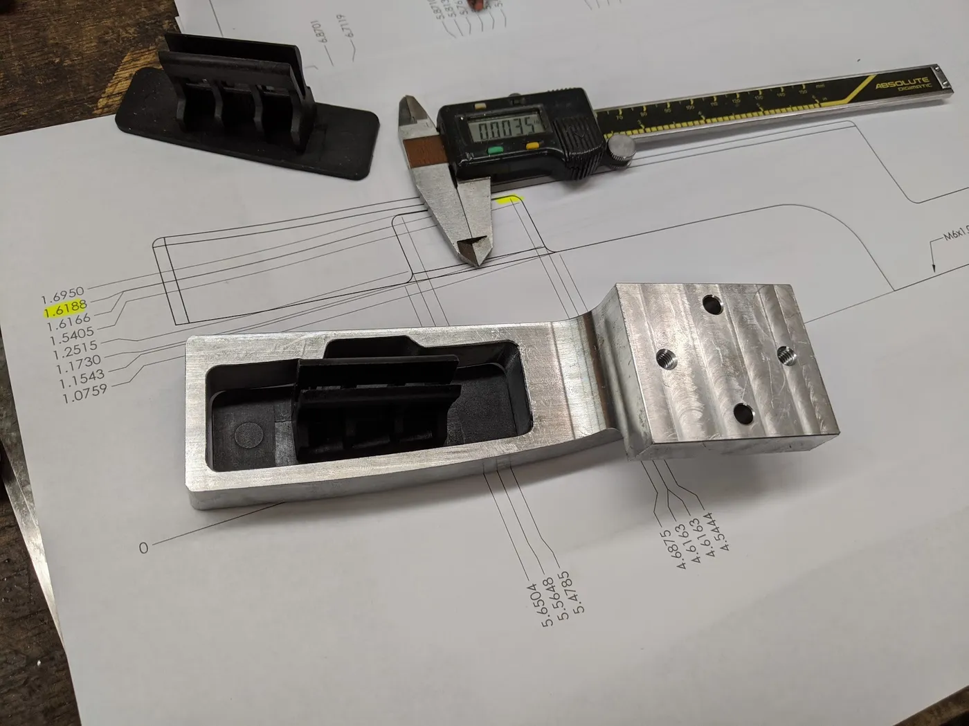 Reverse engineered part with calipers and the dimensioned drawing it produced
